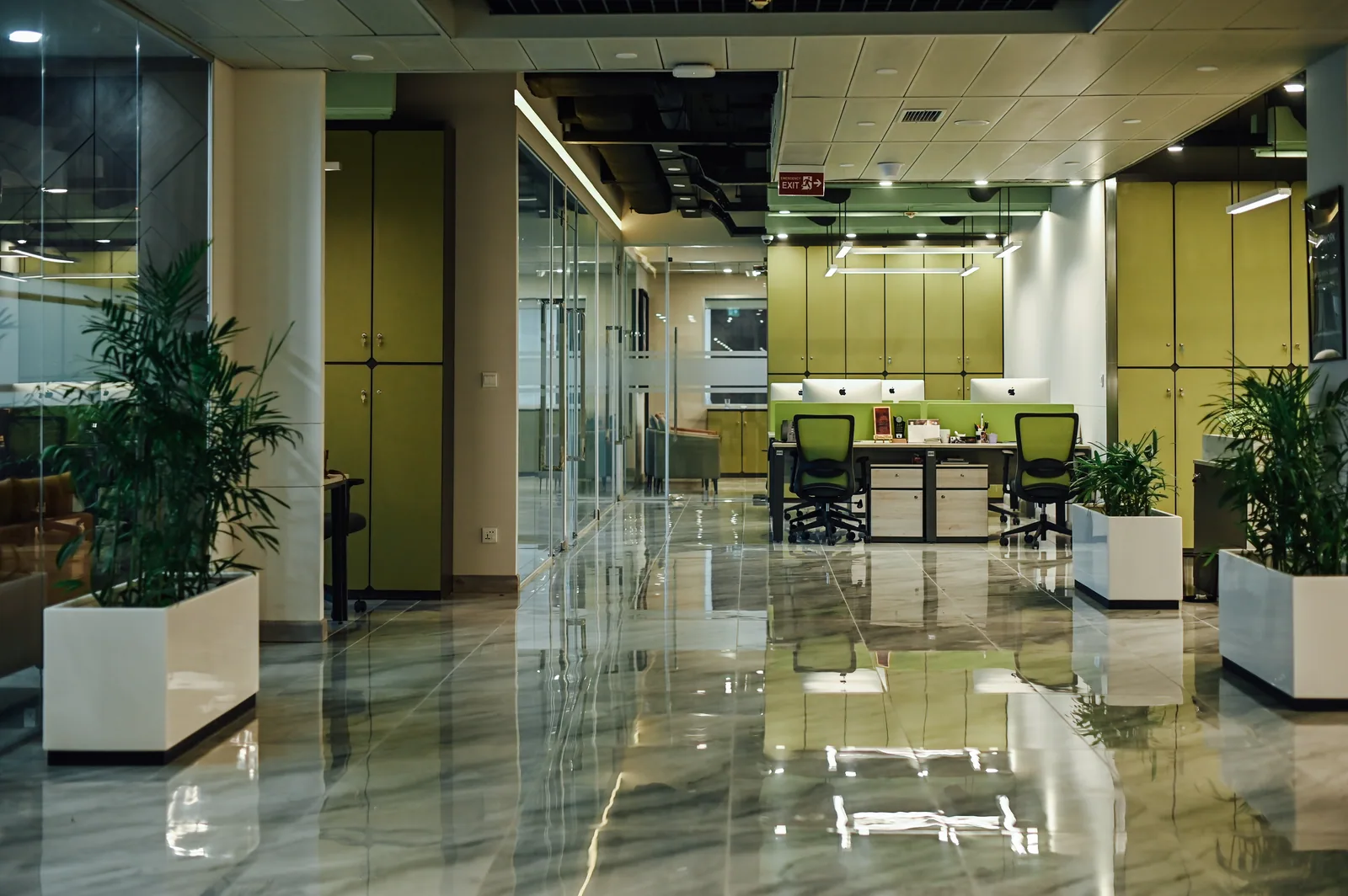 PSO House, 8th-floor rehabilitation, Karachi: Green workstations beyond a bright central aisle. 8th-floor rehabilitation photography.