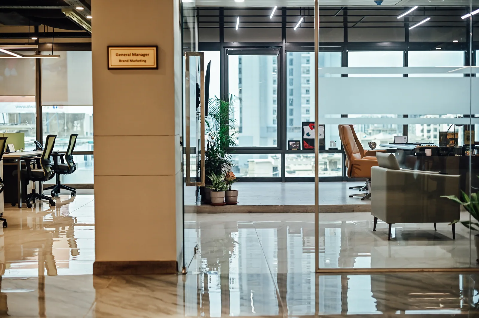 PSO House, 8th-floor rehabilitation, Karachi: A glazed office opens onto the shared floor. 8th-floor rehabilitation photography.