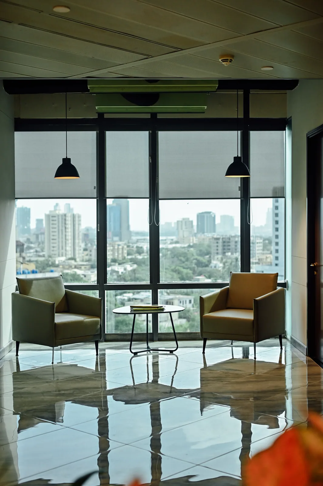 PSO House, 8th-floor rehabilitation, Karachi: Two lounge chairs face the city windows. 8th-floor rehabilitation photography.