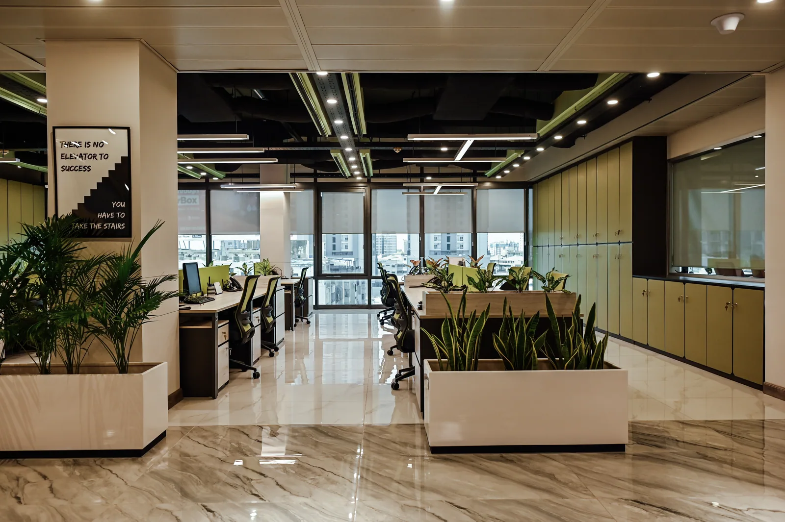 PSO House, 8th-floor rehabilitation, Karachi: Work bays and planters lead towards daylight. 8th-floor rehabilitation photography.