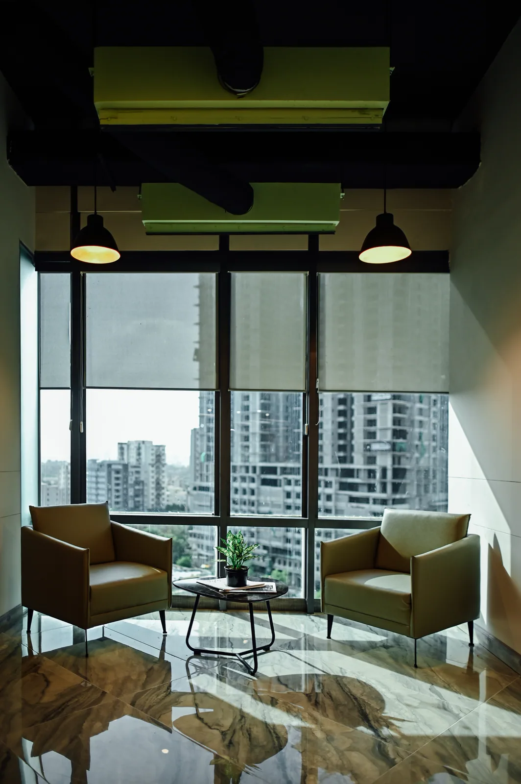 PSO House, 8th-floor rehabilitation, Karachi: A pair of lounge chairs beneath pendant lights. 8th-floor rehabilitation photography.