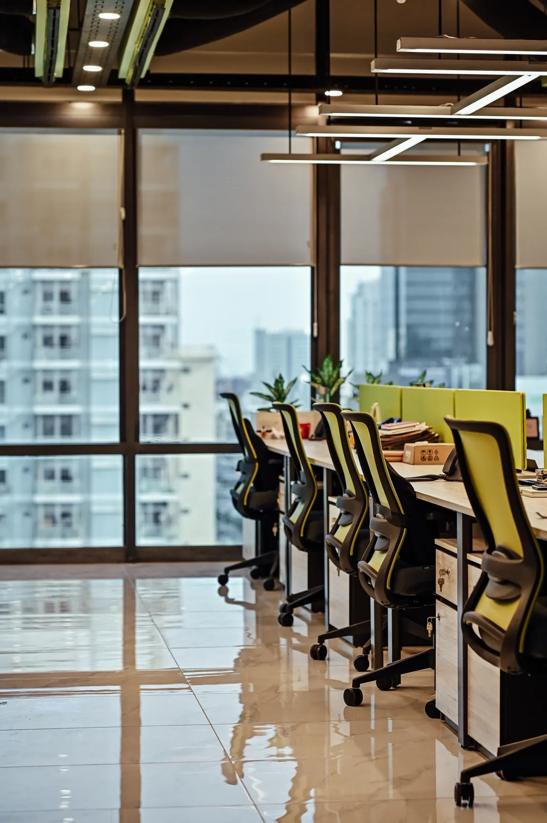 PSO House, 8th-floor rehabilitation, Karachi: A row of workstations beside city glazing. 8th-floor rehabilitation photography.