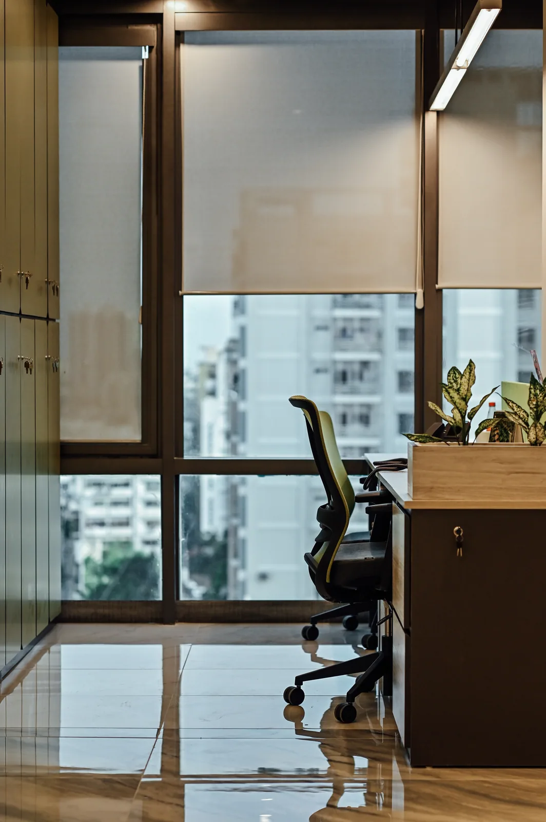 PSO House, 8th-floor rehabilitation, Karachi: A desk and chair against a bright urban outlook. 8th-floor rehabilitation photography.