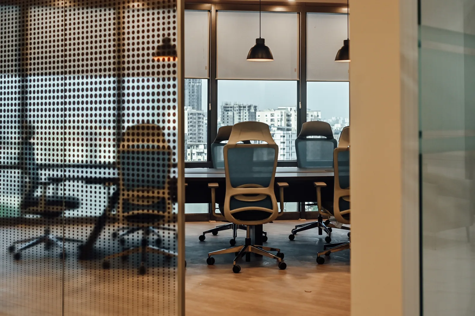 PSO House, 8th-floor rehabilitation, Karachi: A dotted screen filters the conference-room view. 8th-floor rehabilitation photography.