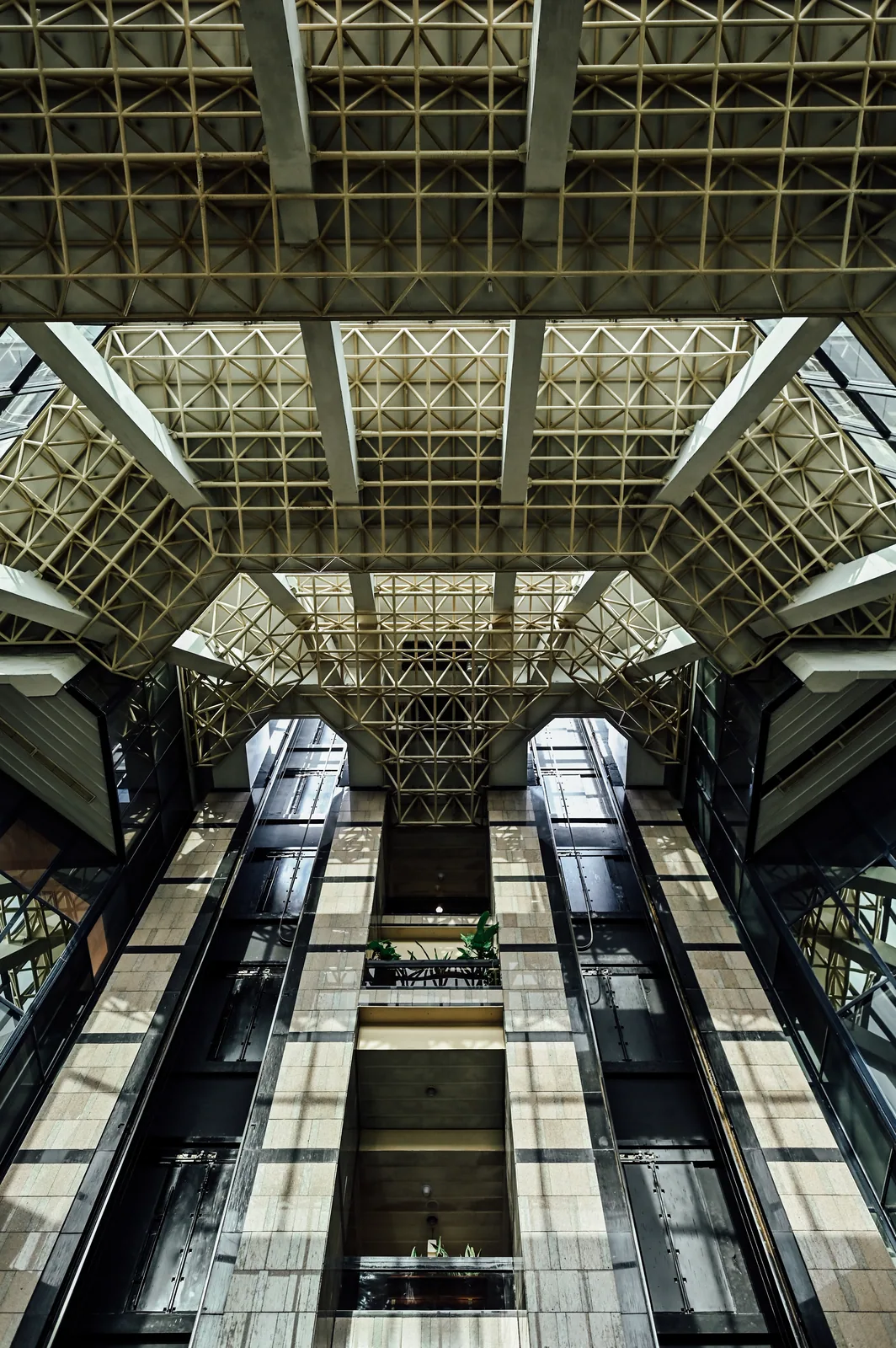 PSO House, 8th-floor rehabilitation, Karachi: Glazed lifts and a geometric roof — building context. Building context photography.
