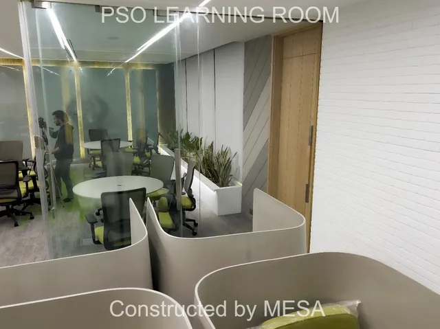 Curved gray individual seating enclosures beside glazing, with a round table and lime-green chairs beyond; original PSO Learning Room and MESA overlays visible.
