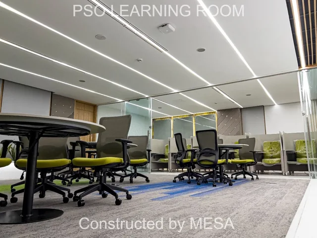 Low-angle view of round tables and gray mesh-backed chairs with lime-green seats beneath linear ceiling lights, with original project and MESA overlays.