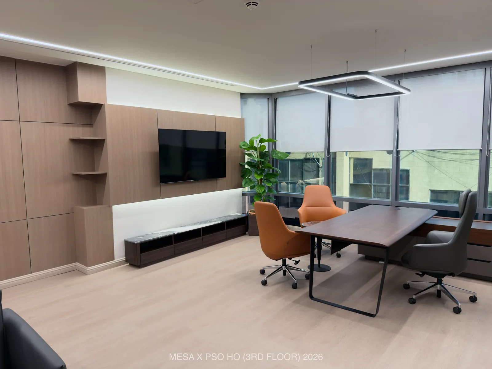 PSO House / Third floor / Executive room with a meeting table, warm wall panels and a low display unit.