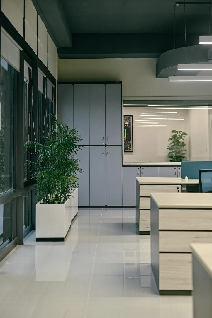 PSO 6th & 7th: Desks, storage and planting along the window wall. 6th–7th-floor interior photography.