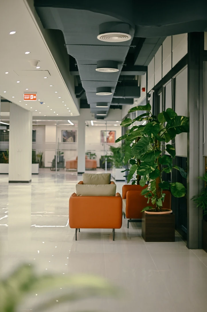 PSO 6th & 7th: Lounge chairs line the planted window edge. 6th–7th-floor interior photography.