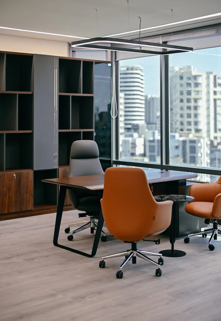 PSO 6th & 7th: Orange visitor chairs face a desk and city view. 6th–7th-floor interior photography.
