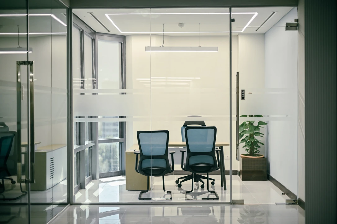 PSO 6th & 7th: Blue chairs and a desk behind clear glazing. 6th–7th-floor interior photography.