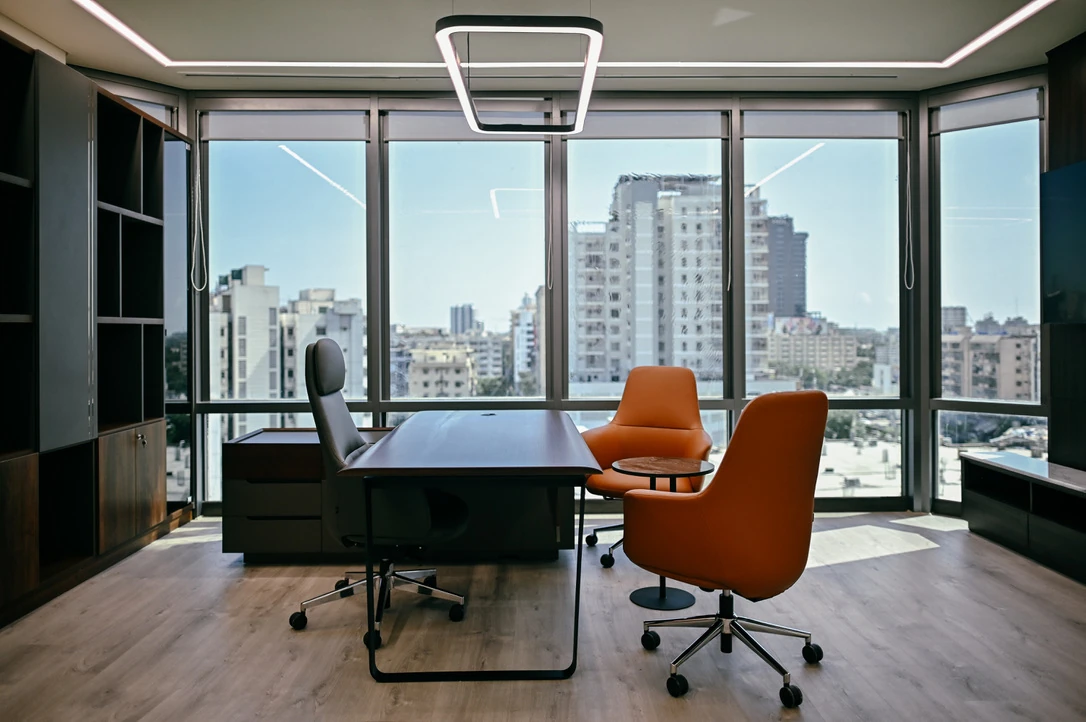 PSO 6th & 7th: An office desk and visitor chairs before wide glazing. 6th–7th-floor interior photography.