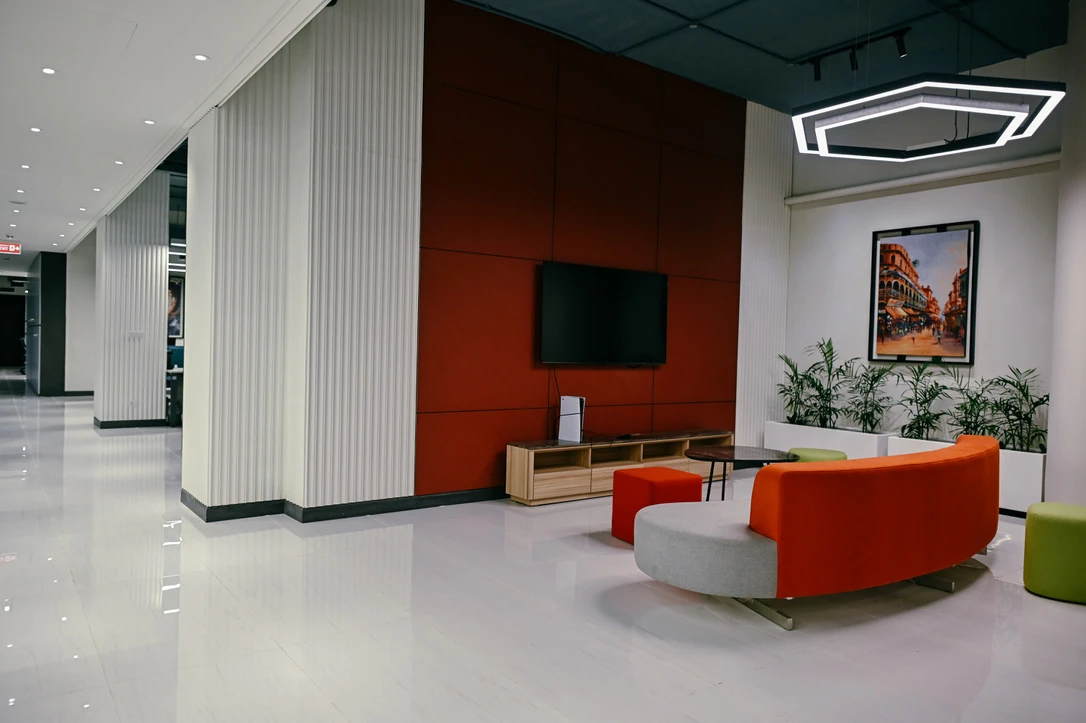 PSO 6th & 7th: Orange and grey seating beside a tall screen wall. 6th–7th-floor interior photography.