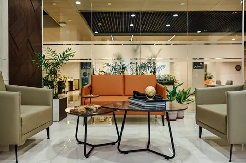 PSO House, 8th-floor rehabilitation, Karachi: An orange sofa and armchairs gather around low tables. 8th-floor rehabilitation photography.