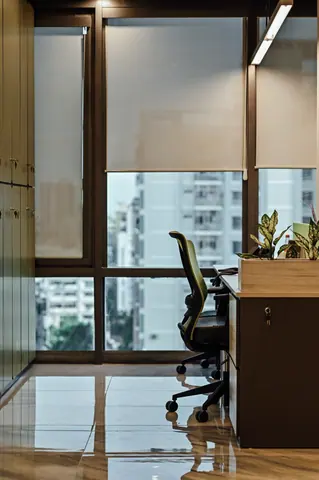 PSO House, 8th-floor rehabilitation, Karachi: A desk and chair against a bright urban outlook. 8th-floor rehabilitation photography.