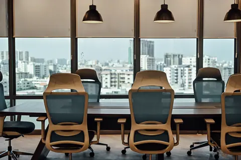 PSO House, 8th-floor rehabilitation, Karachi: Pendant lights repeat above a city-facing conference table. 8th-floor rehabilitation photography.