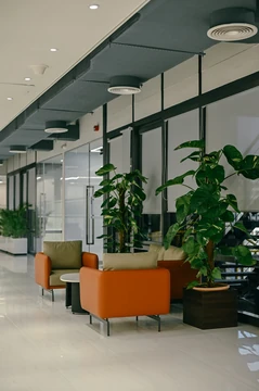 PSO 6th & 7th: Orange lounge chairs beside a planted window edge. 6th–7th-floor interior photography.