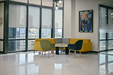 PSO 6th & 7th: A yellow sofa and chairs gather around low tables. 6th–7th-floor interior photography.