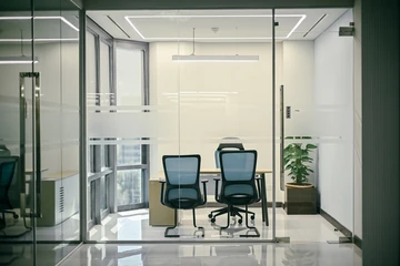 PSO 6th & 7th: Blue chairs and a desk behind clear glazing. 6th–7th-floor interior photography.