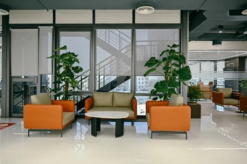 PSO 6th & 7th: Orange armchairs gather around a small round table. 6th–7th-floor interior photography.
