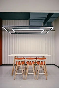 PSO 6th & 7th: A high table and stools beneath a framed light. 6th–7th-floor interior photography.